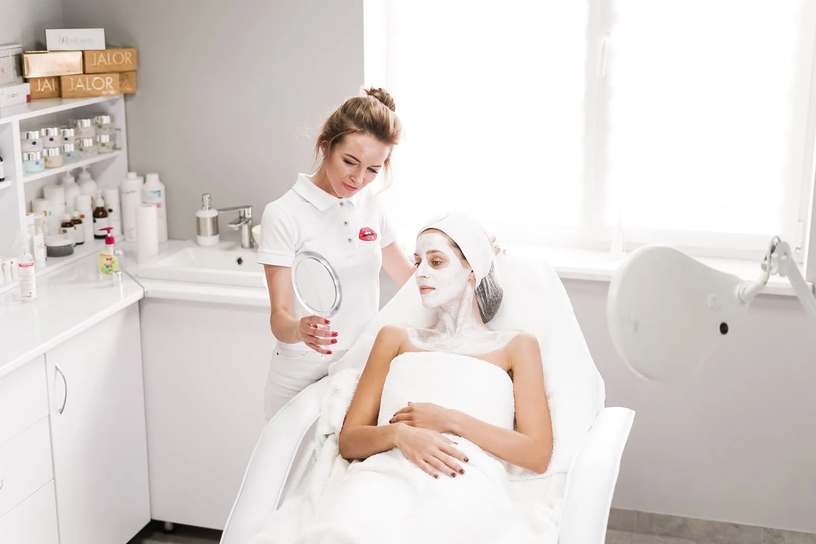 An esthetician showing a client the results of a treatment