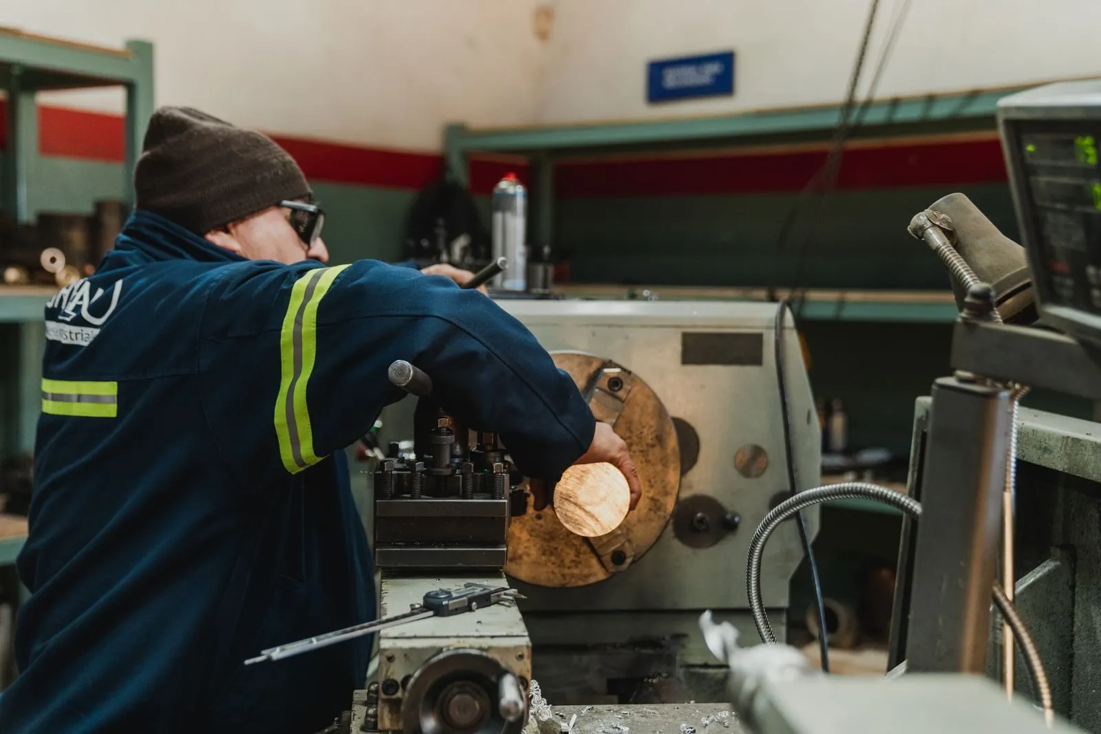 A worker operating a lathe in a machine shop