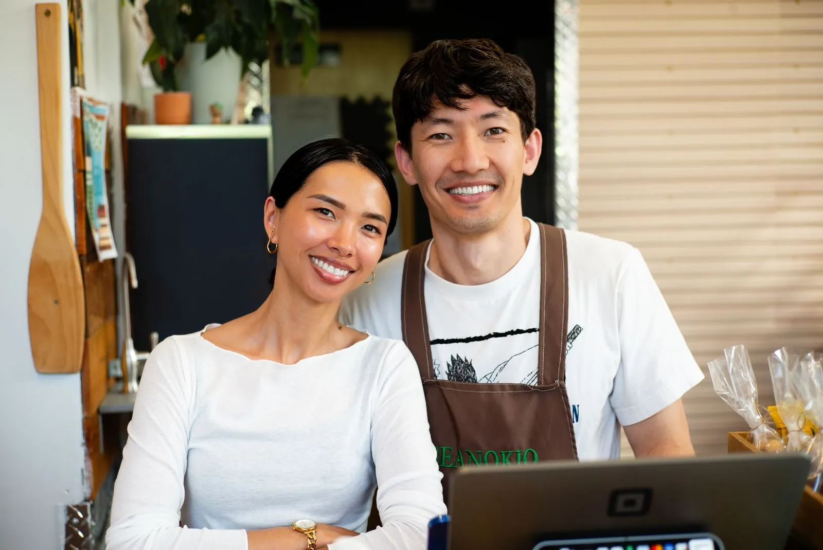 Café owners smiling behind their counter